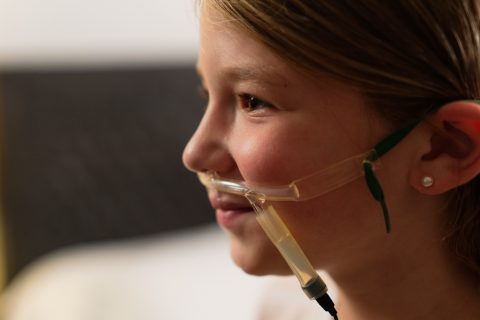 A child wearing a nasal cannula and airflow sensor as part of a Snap Diagnostics' home sleep apnea test